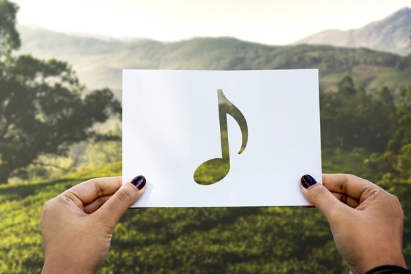 une note de musique devant un paysage de montagne