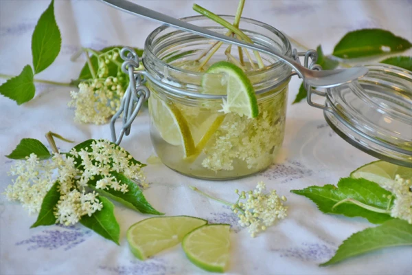 Des fleurs de sureau et du citron macèrent dans un bocal