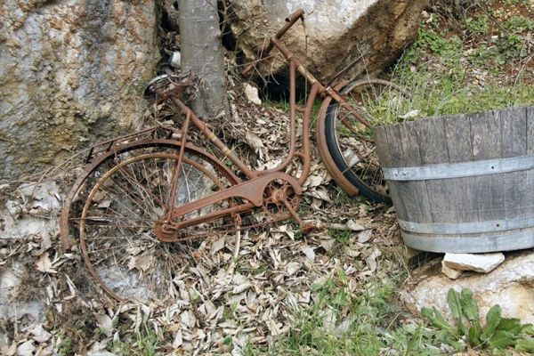 Un vieu vélo couché contre des pierres