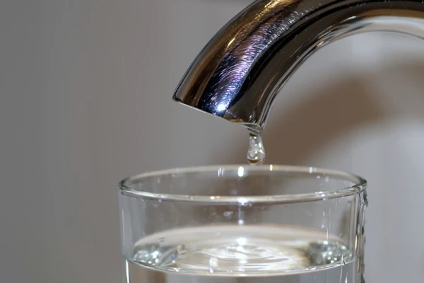 Un verre d'eau sous un robinet