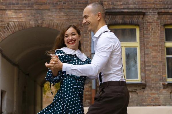 Un couple tout sourire danse